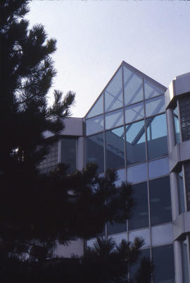 Photograph of the glass peak of NX building viewed against a clear sky