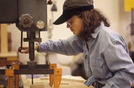 Photograph of an Industrial Design student at a drill press