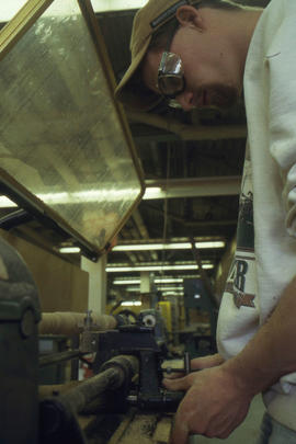 A photograph of a student using a lathe in the woodworking lab