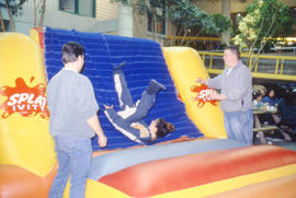 Photograph of a student bouncing around during an event in the Student Centre