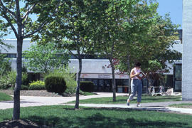 Photograph of a student walking to the main entrance of D building