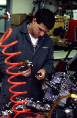 Photograph of a student working on an engine