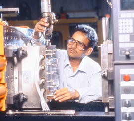 Photograph of a student working with a molding equipment