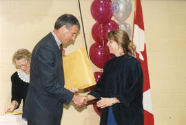 Photograph of Dr. Robert A "Squee" Gordon presenting an award at the President's Breakfast