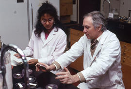 Photograph of an instructor explaining the use of a petri dish for the growing of cultures