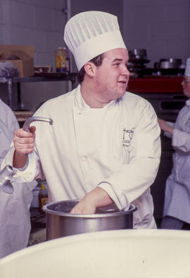 Photograph of a culinary student holding a dough hook