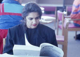 Photograph of a student reading a book in the library