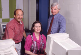 Photograph of three staff members in the HRT computer lab