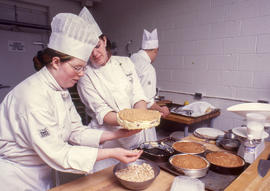 Photograph of students in the Culinary program working together to prepare cakes in the lab