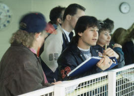 Photograph of students taking notes while standing beside a barrier railing