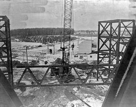 Photograph of a crane hoisting one of the support structures for the back wall of building "...