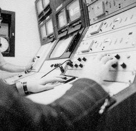 Photograph of Technicians operating a television control console in the IMC