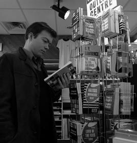 Photograph of a student browsing the books in the bookstore