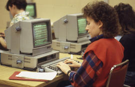 Photograph of a Journalism student entering an article in a computer