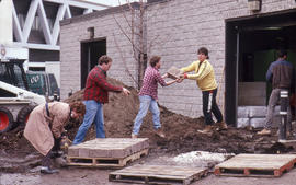 Photograph of Landscaping students organizing blocks for a retaining wall by the greenhouse