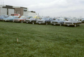 Photograph of Cars Parked on the Unpaved Parking Lot by the L Building