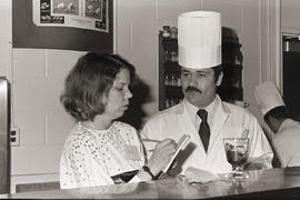 Photograph of a chef in conversation with an unknown person