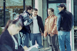 Photograph of students standing outside and engage in conversation