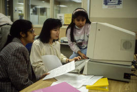 Photograph of three students working at a computer