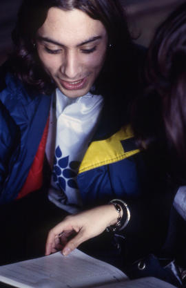 Photograph of two students reviewing a textbook in an unknown location