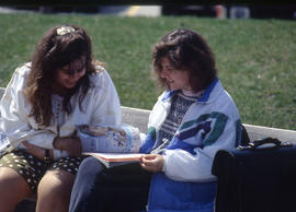 Photograph of two students flipping through a magazine