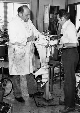 Photograph of George Kay and Another Faculty Member Working on a Marine Outboard Motor