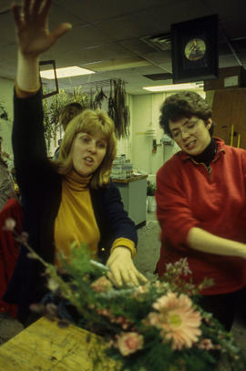 A photograph of a professor examining a floral arrangement