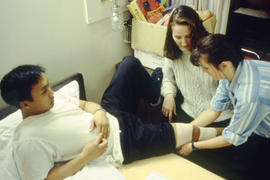 Photograph of nursing students giving first aide to another student