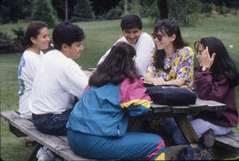 Photograph of Students Sitting on a Picnic Bench in the Arboretum