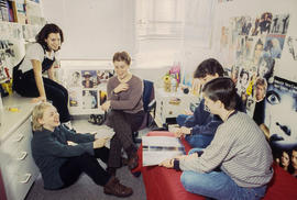 Photograph of students seated in a residence dorm and chatting