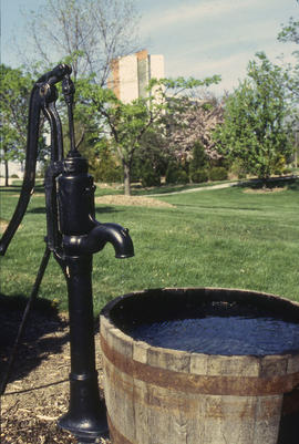 Photograph of a replica hand pump and an oak barrel