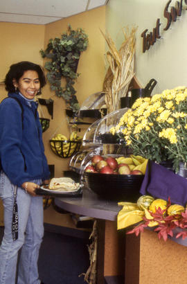 Photograph of a student examining choices of fruits and pastries