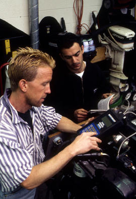 Photograph of Robert Smith and student performing engine diagnostics