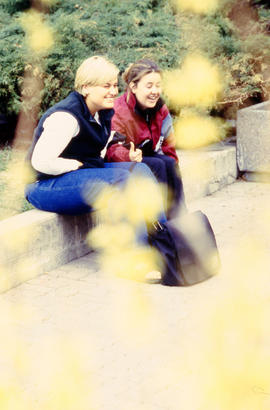 Photograph of students sitting on the curb