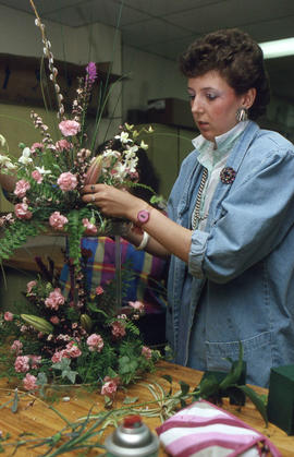 Photograph of an unknown person creating a floral arrangement