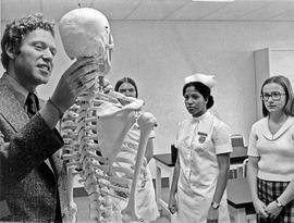 Photograph of Henry Ruschin Teaching with a Model Skeleton in a Nursing Class