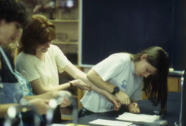 Photograph of a student in the nursing program drawing blood from another student's finger for te...