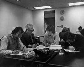 Photograph of Jim Moyes Sitting with Students Reviewing their Work