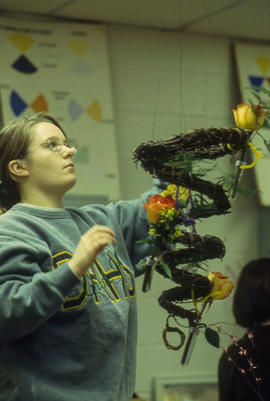 A photograph of a Retail Floriculture student creating a floral arrangement