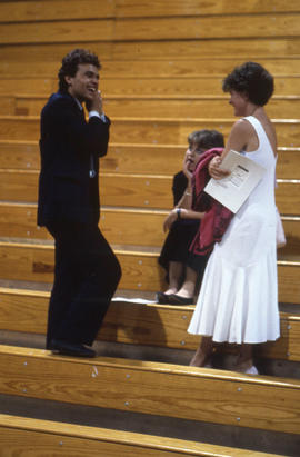 Photograph of Graduates talking in the bleachers in the Athletic Centre