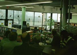 Photograph of Wayson Choy reading in the library