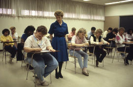 Photograph of an instructor overlooking students studying at their desks